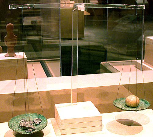 上图：主前1150-586年古代以色列的铜制天平和砝码。商人把银子放在左边的盘子上，砝码放在右边的盘子上。砝码上标着重量，但现在出土的标着相同重量的砝码石，很少重量是完全一样的。