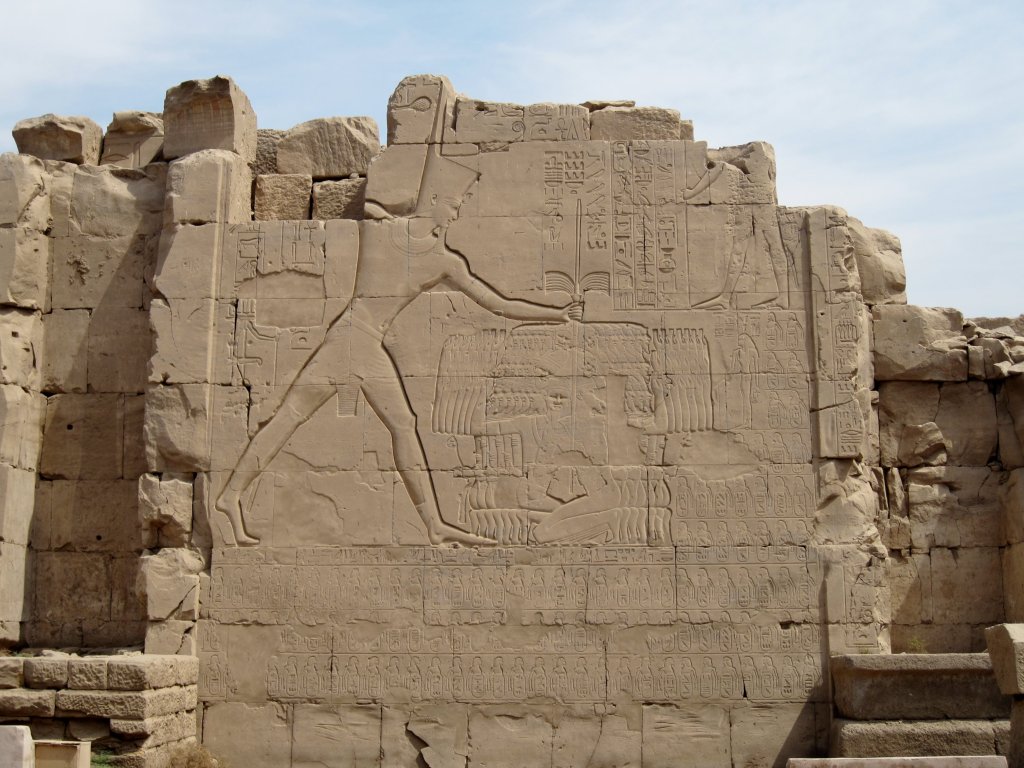 上图：埃及底比斯卡纳克神庙（Karnak Temple）的米吉多战役浮雕，描绘图特摩斯三世（Thutmose III，主前1479-1425年在位）一手抓住一群迦南俘虏的头发，一手在施行惩罚。「膀臂」在古代中东常被用来比喻君王的能力和军事力量。「打折埃及王法老的膀臂」（结三十21），比喻削弱法老的力量。