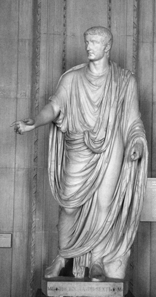 上图：穿着托加长袍的罗马皇帝提庇留（Tiberius，主后14-37年）。宽大的托加长袍（Toga）是最能体现古罗马男子服饰特点的服装。从主前5世纪开始，托加就被看作罗马公民的特有标志，只有男子才能穿，而女子只能穿斯托拉（Stola）和帕拉（Palla），而奴隶、外来者和被放逐者不准穿托加。大多数罗马人在合法年龄（通常是14-18岁）在正式场合穿成年托加（Toga virilis），未成年的自由民男孩穿有紫色镶边的镶边托加（Toga praetexta）。